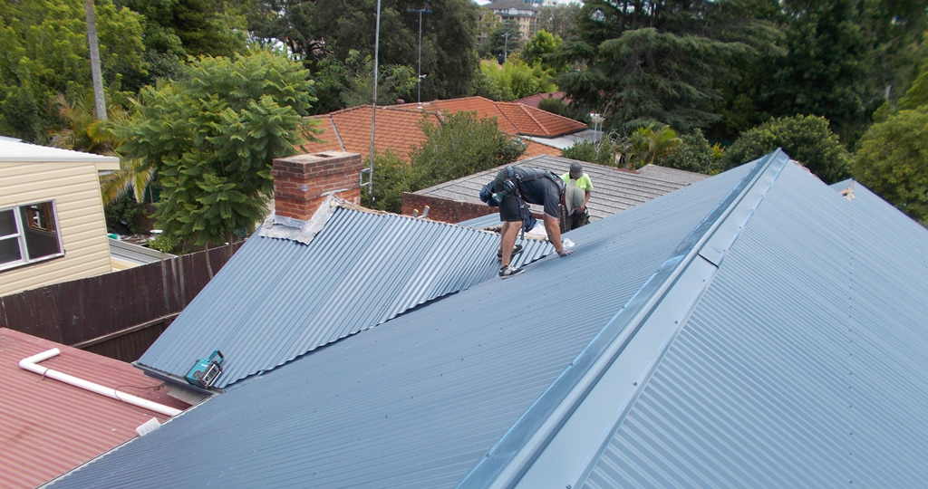 Roofers working on a metal roof.